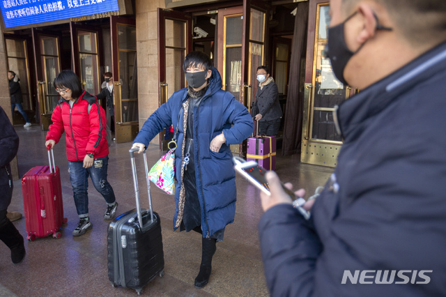 [베이징=AP/뉴시스]20일(현지시간) 중국 베이징 철도역 앞에서 여행객들이 마스크를 쓰고 이동하고 있다. 2020.01.20.