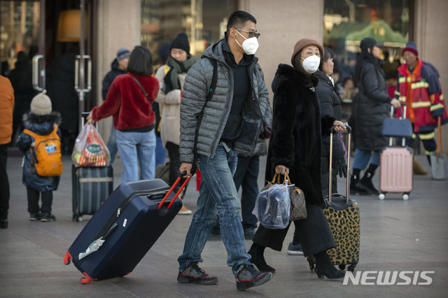 [베이징=AP/뉴시스]20일(현지시간) 중국 베이징의 베이징 철도역 앞에 여행객들이 마스크를 쓰고 이동하고 있다. 중국 정부는 우한 폐렴이 수도 베이징에서도 발생하면서 신종 코로나바이러스에 감염된 사람의 수가 급격히 늘고 있다고 발표했다. 특히 연휴를 맞아 수백만 명이 열차와 비행기를 이용하는, 중국에서 가장 인구 이동이 많은 시기와 겹쳐 대규모 확산이 우려되고 있다. 2020.01.21. 