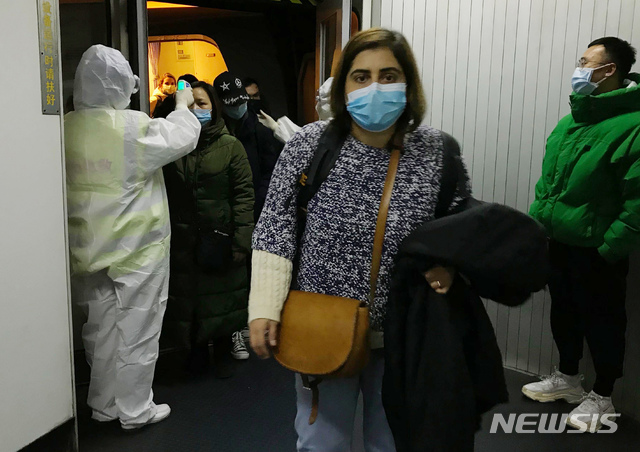 [베이징=AP/뉴시스]보호복을 입은 방역 관계자들이 22일 베이징 공항에서 우한시로부터 도착한 승객들의 체온을 체크하고 있다. 중국은 23일 0시(한국시간 오전 1시) 우한 폐렴 확진 환자 수가 총 547명이며 이중 17명이 숨졌다고 밝혔다. 또 31개 중국 행정구 가운데 23개에서 환자가 발생해 중국의 3분의 2 이상으로 우한 폐렴이 확산됐다고 말했다. 2020.1.23 