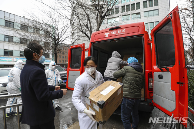 [우한=AP/뉴시스] 지난 26일 중국 후베이성 우한의 한 병원에서 직원들이 차에서 지원받은 의료물품을 내리고 있다. 2020.01.29 