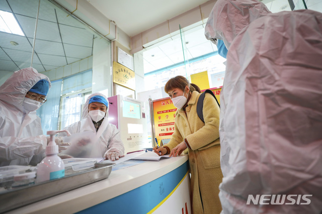[우한=AP/뉴시스]중국 후베이성 우한의 한 지역 보건소에서 지난 27일 의료진이 신종코로나바이러스 감염증 감염으로 의심되는 한 여성과 대화하고 있다. 2020.01.28. 