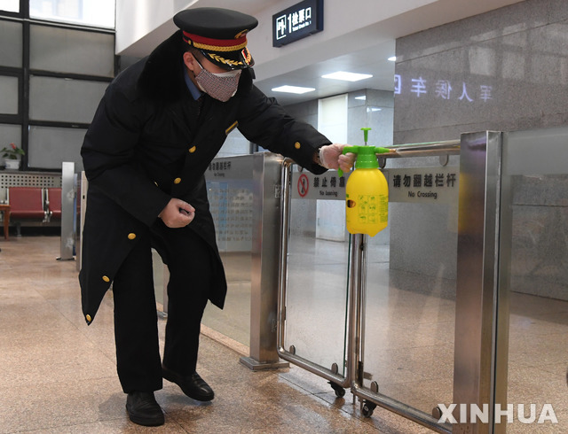 [베이징=신화/뉴시스]28일(현지시간) 중국 베이징의 서베이징 철도역에서 한 역무원이 맞이방 입구를 소독하고 있다. 역 관계자는 신종 코로나바이러스의 확산을 막기 위해 기차와 역의 소독과 여행자의 체온 측정 등의 조치를 강화했다고 밝혔다. 2020.01.28. 