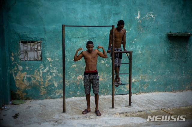 [아바나=AP/뉴시스]5일(현지시간) 쿠바 수도 아바나에서 한 청소년이 철봉 아래에서 자신의 근육을 과시하며 포즈를 취하고 있다. 2020.02.06. 