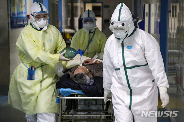 [우한=AP/뉴시스] 중국 후베이성 우한의 한 병원에서 지난 6일 보호복을 입은 의료진이 코로나 19 환자를 격리병동으로 옮기고 있다. 2020.02.20 