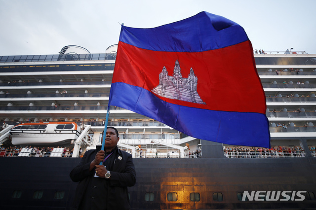 [시아누크빌=AP/뉴시스]지난 14일 캄보디아 시아누크빌 항구에 입항한 유람선 웨스테르담 앞에서 한 남성이 캄보디아 국기를 들고 서 있다. 2020.02.17.