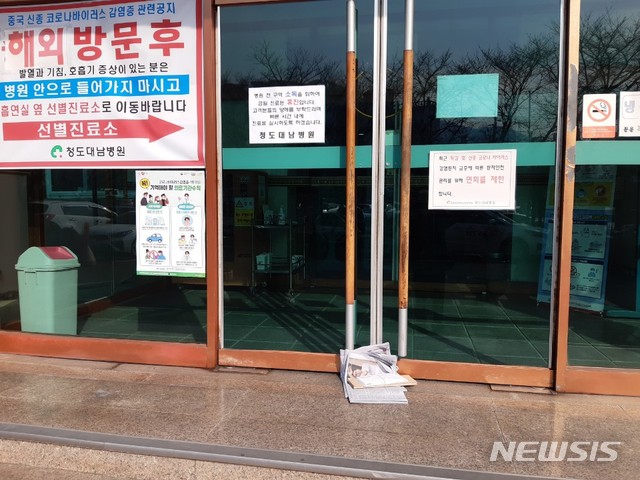 21일 오전 청도 대남병원의 출입문이 봉쇄된 모습. 이날 배달된 신문이 방치돼 있다.
