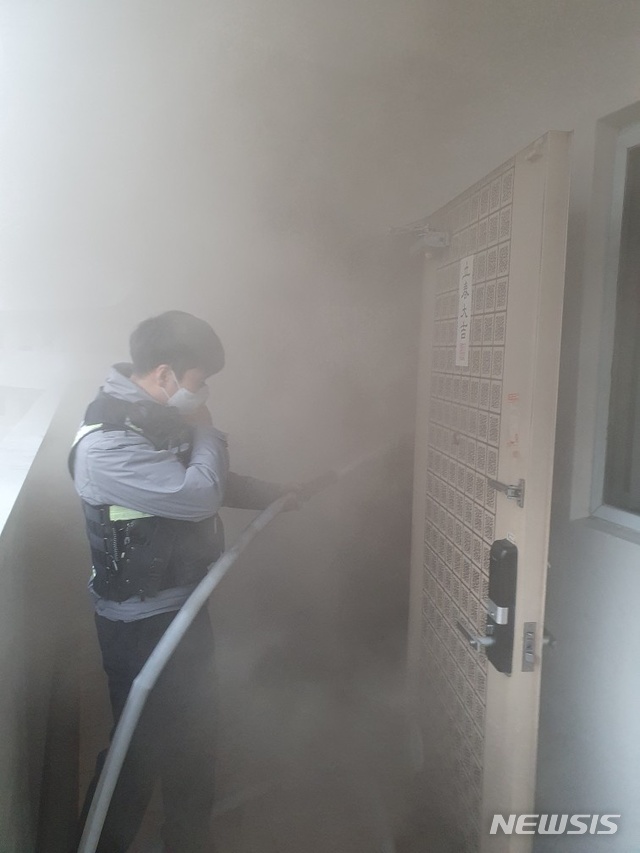 [부산=뉴시스] 22일 오후 5시 54분께 부산 부산진구의 한 아파트 26층 A씨의 집에서 화재가 발생, 경찰관이 소화전을 이용해 불을 끄고 있다. (사진=부산경찰청 제공)