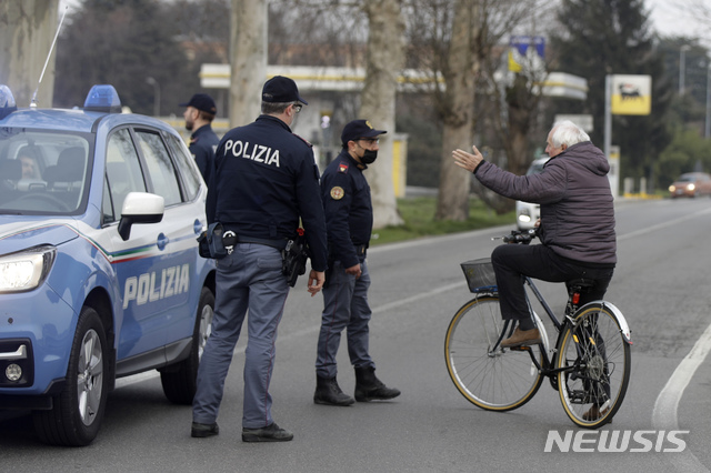  [카사푸스터=AP/뉴시스] 23일 이탈리아 북부 카사푸스터 지역에서 경찰들이 자전거를 탄 시민의 진입을 막고 있다. 이탈리아의 코로나19 확진자는 현재 최소 152명까지 늘어난 가운데 이탈리아 당국은 코로나19 확진자가 집중된 북부 일부 지역에 긴급 봉쇄 조치를 명령했다. 2020.2.23. 