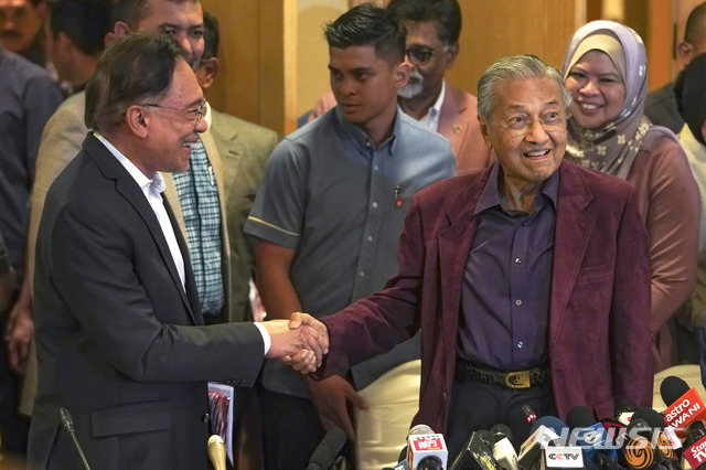[푸트라자야(말레이시아)=AP/뉴시스]마하티르 모하맛 말레이시아 총리(오른쪽)가 지난 2월22일 말레이시아 푸트라자야에서 자신의 후계자로 지명된 안와르 이브라힘 전 부총리와 악수하고 있다. 2020.10.30