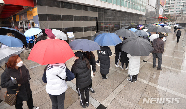 [대구=뉴시스] 이무열 기자 = 대구 북구 침산동 이마트에서 시민들이 우산을 쓰고 마스크를 구입하기 위해 줄지어 차례를 기다리고 있는 모습이다. 2020.02.25. lmy@newsis.com