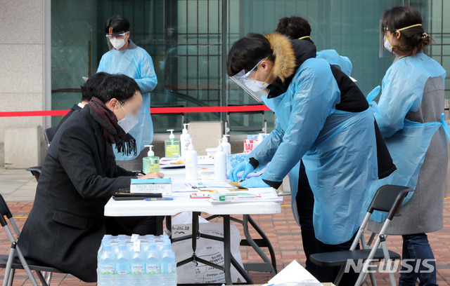 [서울=뉴시스] 고범준 기자 = 명성교회 부목사가 신종 코로나바이러스 감염증(코로나19) 확진 판정을 받은 가운데 26일 오전 서울 강동구 명성교회에 앞에 설치된 선별진료소에서 주민들이 진료를 받기 위해 서류를 작성하고 있다. 2020.02.26. bjko@newsis.com