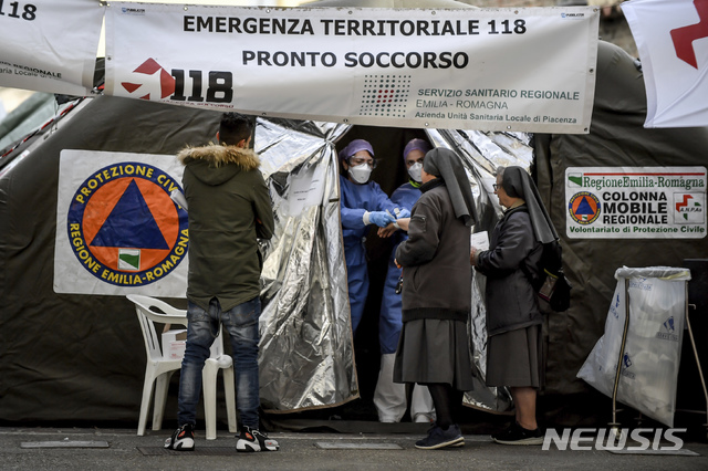 [피아첸차=AP/뉴시스]27일(현지시간) 이탈리아 북부 피아첸차 병원 응급실 옆에 설치된 시민보호청 텐트에서 의료진이 마스크를 쓰지 않은 수녀들과 얘기를 나누고 있다. 의료진이 서 있다. 이탈리아 시민보호청은 27일 기준 코로나19 사망자 수가 17명, 누적 확진자 수는 650여 명으로 늘었다고 밝혔다. 이탈리아는 이란과 함께 아시아 외 지역에서 최근 코로나19 확진자가 급격히 늘어난 국가로 꼽힌다. 2020.02.28.