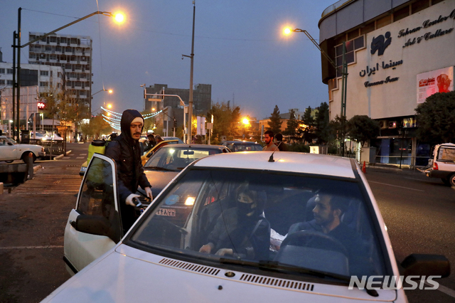 [테헤란=AP/뉴시스] 25일 이란 수도에서 혁명수비대 요원이 코로나 19 방역에 나서 차량들을 내부 소독하고 있다. 2020. 3. 26. 