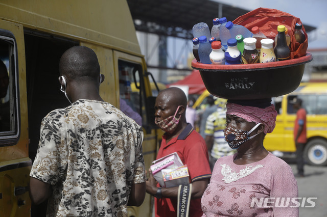 [라고스=AP/뉴시스] 5월5일(현지시간) 신종 코로나바이러스 감염증(코로나19)가 확산하는 가운데 나이지리아 라고스에서 한 여성이 마스크를 쓴 채 물을 팔고 있다. 2020.07.06.