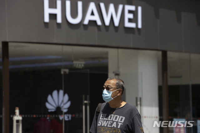 [베이징=AP/뉴시스] 지난해 5월18일(현지시간) 중국 베이징에서 코로나19 감염을 막기 위해 마스크를 쓴 한 남성이 화웨이 매장 앞을 지나가고 있다. 2021.04.20.
