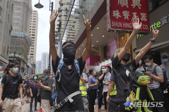 [홍콩=AP/뉴시스] 홍콩 시내 중심가에서 24일 시위 참가자들이 중국의 홍콩 국가보안법 제정에 반대하는 시위를 벌이고 있다. 이들이 펼쳐 보이고 있는 다섯개 손가락과 한개의 손가락은 "5대 요구 사항을 단 하나라도 빼지 말고 모두 이행하라"는 뜻이다. 시위대의 5대 요구는 송환법 공식 철회, 경찰 강경 진압 책임자 문책, 시위대를 ‘폭도’로 규정한 입장 전면 철회, 체포된 시위대 석방, 행정장관 직선제 실시다. 2020.05.24