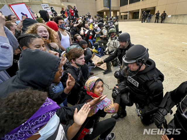 [스포캔=AP/뉴시스] 지난달 31일(현지시간) 미 워싱턴주 스포캔의 법원 앞에 모인 인종차별 반대 시위대가 존경과 무릎을 꿇은 경찰관들과 손을 잡고 있다. 시위대 다수는 마스크를 착용하지 않은 모습이다. 2020.6.2.