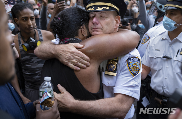 [뉴욕=AP/뉴시스]1일(현지시간) 미국 뉴욕에서 조지 플로이드의 죽음에 항의하는 시위대가 시위를 잠시 멈춘 사이 테렌스 모나한 뉴욕시 경찰서장이 한 운동가와 포옹하고 있다. 2020.06.02.