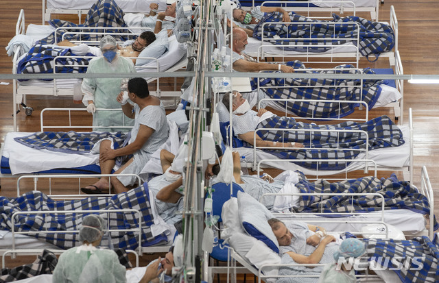 [상파울루(브라질)=AP/뉴시스]브라질 상파울루 외곽 산토 안드레의 한 체육관 안에 세워진 야전병원 침대에 9일(현지시간) 신종 코로나바이러스 감염증(코로나19) 환자들이 누워 있다. 지난 5일 코로나19 누적 사망자 수 발표를 중단했던 브라질 보건부는 발표를 재개하라는 대법원의 명령에 따라 48시간 내에 발표를 재개하겠다고 밝혔다. 2020.6.10