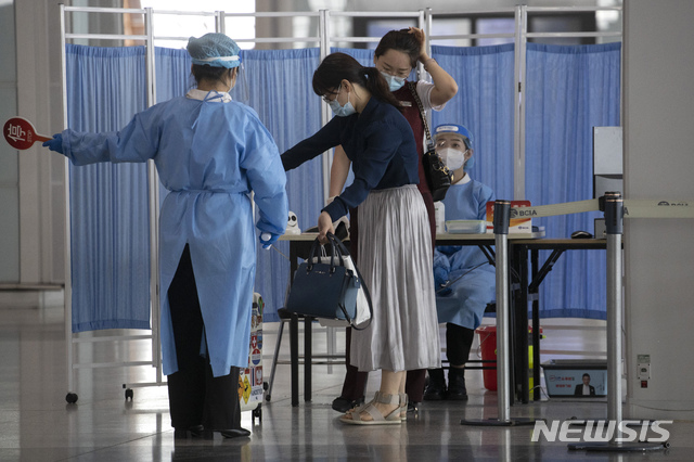 [베이징=AP/뉴시스]17일 중국 베이징의 베이징 수도공항 제2터미널에서 출입객들이 신종 코로나바이러스 감염증(코로나19) 관련 측정을 받고 있다. 2020.06.17.