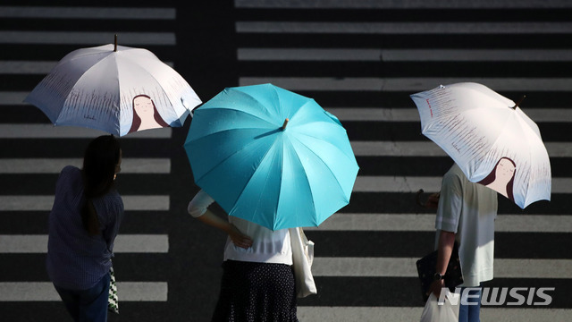 [서울=뉴시스] 고범준 기자 = 비가 내리고 있는 지난달 29일 오후 서울 종로구 세종대로 광화문 네거리에서 시민들이 우산을 쓰고 신호를 기다리고 있다. 2020.06.29. bjko@newsis.com