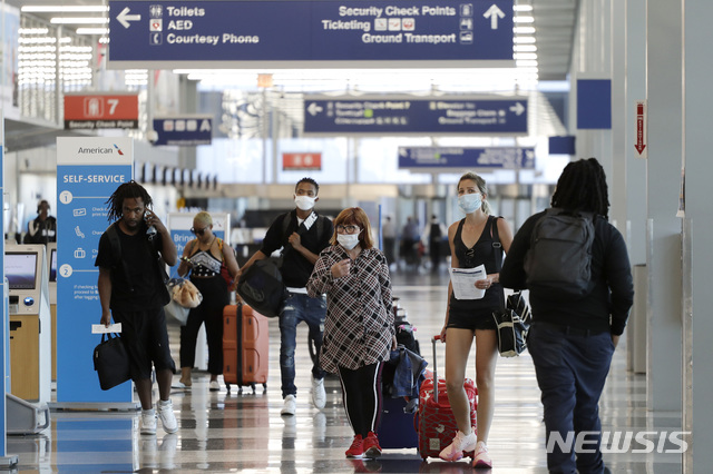 [시카고=AP/뉴시스]지난 6월16일 시카고 오헤어 국제공항에서 마스크를 착용한 여행객들이 이동하는 모습. 2020.07.03.