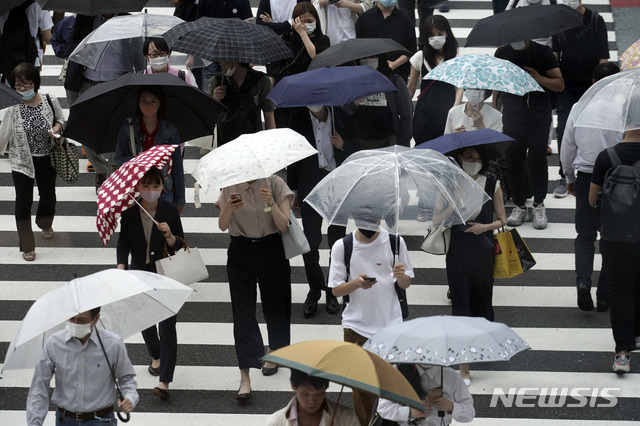 [도쿄=AP/뉴시스]지난 10일 일본 도쿄의 한 횡단보도를 우산을 쓴 시민들이 건너고 있다. 2020.07.10.
