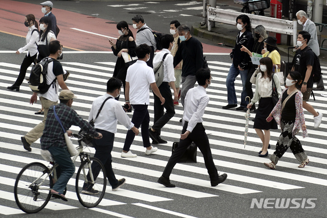 [도쿄=AP/뉴시스]지난 16일 일본 도쿄 거리의 한 횡단보도에서 신종 코로나바이러스 감염증(코로나19) 예방을 위해 마스크를 쓴 시민들이 걸어가고 있다. 2020.07.17.