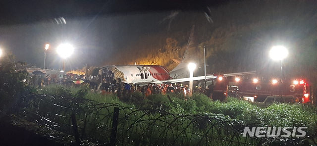 [코지코드=AP/뉴시스]7일(현지시간) 인도 케랄라주 코지코드의 캘리컷 국제공항에 착륙하려던 에어인디아 익스프레스 여객기가 미끄러지면서 두 동강 나 있다. 승무원 등 191명이 탑승하고 두바이를 떠난 이 항공기는 캘리컷 공항에 폭우가 내려 두 차례 착륙 시도 끝에 사고를 당했다. 현지 경찰은 조종사 1명 등 최소 15명이 숨지고 112명이 다쳤다고 밝혔다. 2020.08.08.