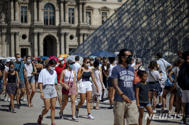 [파리=AP/뉴시스]12일(현지시간) 프랑스 파리 루브르박물관 앞을 마스크를 쓴 사람들이 지나고 있다. 