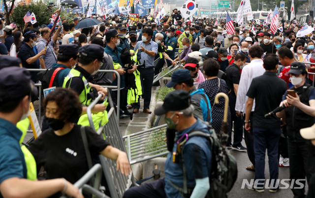 [서울=뉴시스]추상철 기자 =보수단체 집회 참가자들이 15일 오전 서울 종로구 광화문광장에서 8·15 국민대회 집회중 경찰이 세워놓은 바리게이트를 넘어 도로로 나오고 있다. 2020.08.15. scchoo@newsis.com