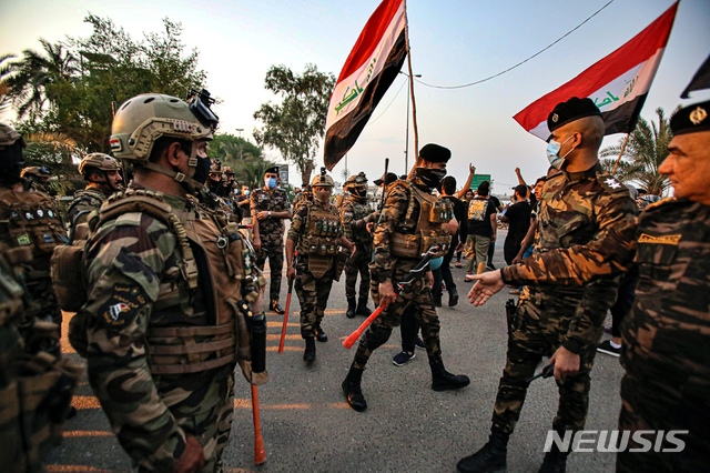[바스라=AP/뉴시스]15일(현지시간) 이라크 바스라에서 보안군이 자유 총선을 요구하는 반정부 시위대의 의회 청사 진입을 막고 있다. 2020.09.16. 