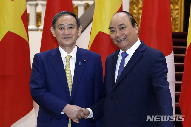 [하노이=AP/뉴시스]베트남을 공식 방문한 스가 요시히데(왼쪽) 일본 총리가 19일 하노이 정부청사에서 응우옌 쑤언 푹 베트남 총리와 만나 악수하고 있다. 2020.10.19.