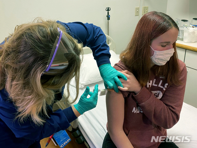 [신시내티= AP/뉴시스] 파이저가 개발중인 코로나19 백신 임상시험에 자원해 참가한 여학생 케이틀린 에반스가 지난 10월 14일 신시내티 아동병원 의료진에게 백신 주사를 맞고 있다.  