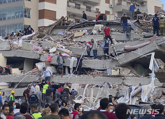 [이즈미르=AP/뉴시스]30일(현지시간) 터키 해안과 그리스 사모스섬 사이 에게해에서 발생한 규모 7.0의 지진으로 인근 도시 이즈미르에서 건물이 무너져 구조대가 잔해에 갇힌 사람들을 수색하고 있다. 터키 당국은 인명 피해가 계속 늘고 있다며 지금까지 최소 12명이 숨지고 419명이 다쳤다고 밝혔다. 2020.10.31.
