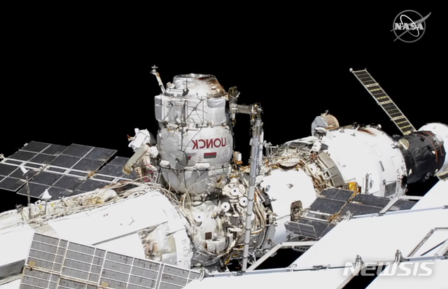 [워싱턴=AP/뉴시스]미 항공우주국이 18일(현지시간) 공개한 사진에 러시아 우주인 세르게이 리지코프(왼쪽 빨간 줄)와 세르게이 쿠드-스베르치코프가 국제우주정거장(ISS) 바깥에서 우주 유영을 하면서 작업하고 있다. 2020.11.19.