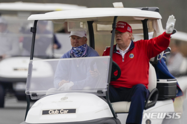 [스털링=AP/뉴시스] 26일(현지시간) 도널드 트럼프 미국 대통령(오른쪽)이 버지니아주 스털링에 있는 트럼프 내셔널 골프 클럽에서 골프 카트를 운전하고 있다. 2020.11.28. 