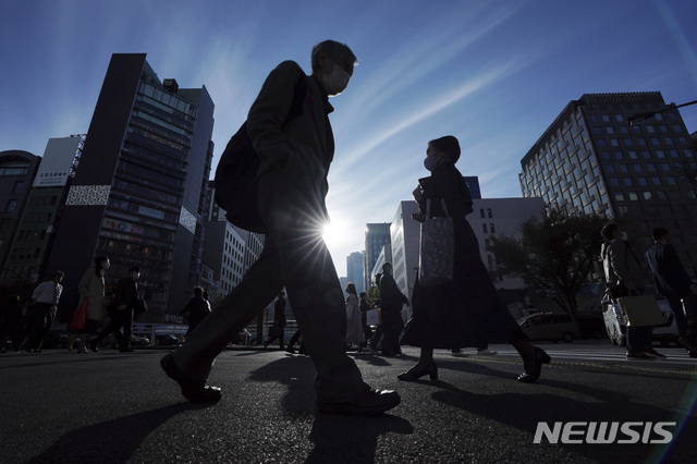 [도쿄=AP/뉴시스]지난달 30 일본 도쿄의 거리를 신종 코로나바이러스 감염증(코로나19) 예방을 위해 마스크를 착용한 사람들이 걷고 있다. 2020.12.01. 