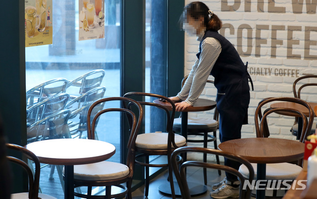 [서울=뉴시스] 카페 직원이 테이블과 의자를 정리하고 있는 모습. 기사 본문과는 무관한 사진