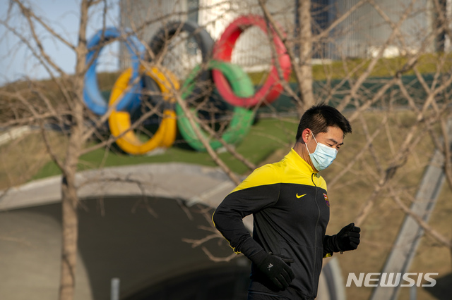 [베이징=AP/뉴시스] 2월2일(현지시간) 중국 베이징 올림픽 타워 앞에서 한 남성이 뛰고 있다. 중국은 2022년 베이징 동계올림픽 개최국이다. 2021.04.19. 