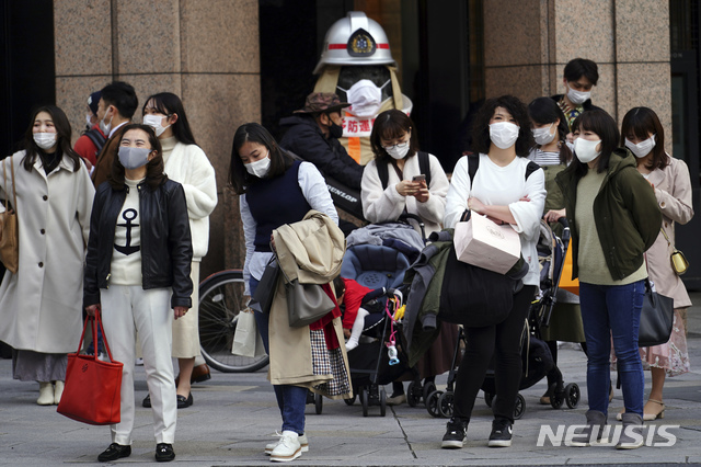[도쿄=AP/뉴시스]지난 1일 일본 수도 도쿄의 한 교차로에서 시민들이 신종 코로나바이러스 감염증(코로나19) 감염 예방을 위해 마스크를 쓴 채 신호를 기다리고 있다. 2021.03.02.