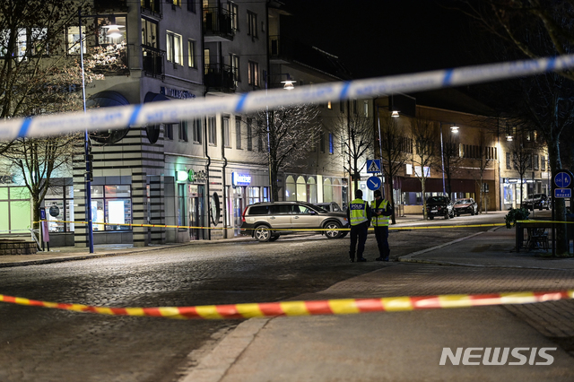 [베틀란다(스웨덴)=AP/뉴시스]한 20대 남성이 도끼를 휘둘러 8명이 부상한 스웨덴 베틀란다의 사고 현장에 차단선이 쳐진 가운데 경찰들이 현장을 지키고 있다. 스웨덴 경찰은 이 사건을 테러 공격으로 의심, 조사하고 있다고 밝혔다. 부상자 가운데 몇명은 중상인 것으로 전해졌지만 사망자는 발생하지 않았다. 2021.3.4 
