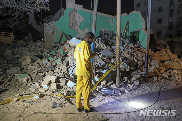 [모가디슈=AP/뉴시스]5일(현지시간) 소말리아 수도 모가디슈의 한 유명 음식점에서 폭발이 일어나 한 남성이 무너진 건물 주변을 살피고 있다. 경찰은 이 식당에 폭발물을 가득 실은 차량이 돌진, 폭발해 최소 20명이 숨지고 30여 명이 다쳤다고 밝혔다. 2021.03.06.