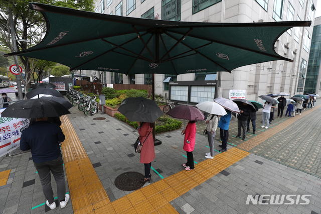 [서울=뉴시스]이윤청 기자 = 국내 코로나19 신규 확진자 수가 587명으로 집계된 12일 서울 중랑구 보건소에 마련된 코로나19 선별진료소에서 시민들이 우산을 쓰고 대기하고 있다. 2021.04.12. radiohead@newsis.com