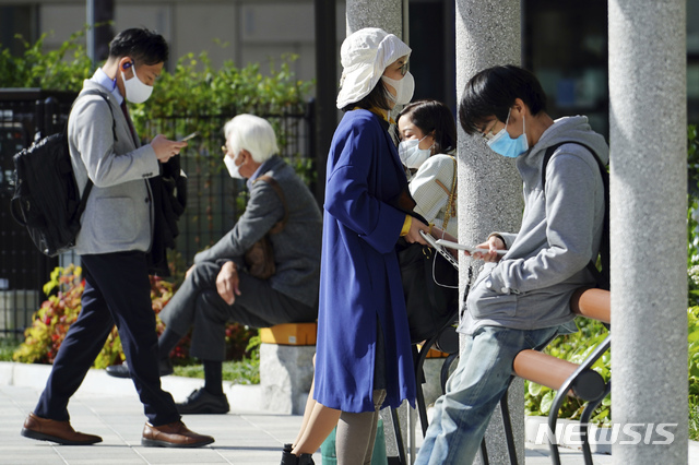 [도쿄=AP/뉴시스]15일 일본 도쿄의 한 공원에서 시민들이 코로나19 감염 예방을 위해 마스크를 착용한 채 오후를 즐기고 있다. 2021.04.15.