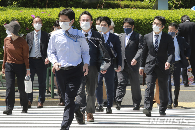 [도쿄=AP/뉴시스]19일 일본 도쿄에서 코로나19 확산을 막기 위해 마스크를 쓴 시민들이 건널목을 건너고 있다. 고이케 유리코 도쿄도지사와 요시무라 히로후미 오사카부 지사는 "코로나19의 심각한 상황이 계속되고 있다”라며 대책 회의를 통해 긴급사태 선언 발령을 국가에 요청할 것을 시사했다. 2021.04.19. 