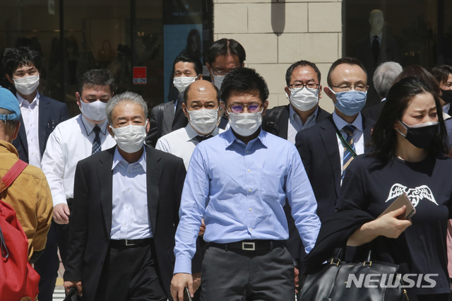 [도쿄=AP/뉴시스]20일 일본 도쿄에서 코로나19 감염 예방을 위해 마스크를 착용한 시민들이 길을 건너고 있다. 2021.04.20.