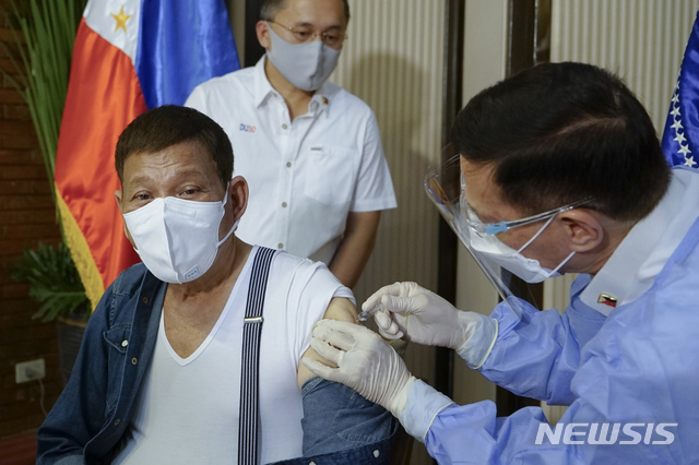 [마닐라=AP/뉴시스]로드리고 두테르테(왼쪽) 필리핀 대통령이 지난 3일(현지시간) 마닐라 말라카낭 대통령궁에서 프란시스코 두케 보건장관으로부터 중국의 시노팜 백신을 접종하고 있다. 시노팜 백신은 필리핀에서 정식 사용 승인이 나지 않아 두테르테 대통령의 백신 접종을 놓고 논란이 일고 있다. 2021.05.06.