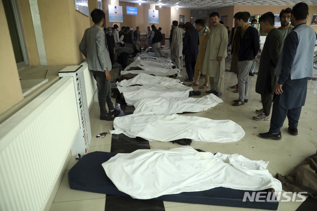 [카불(아프가니스탄)=AP/뉴시스]아프가니스탄 수도 카불의 남성들이 8일 카불의 한 병원에서 이날 발생한 여학교 겨냥 폭탄 공격으로 숨진 희생자들의 시신을 확인하기 위해 모여 있다. 이날 공격으로 인한 사망자가 50명으로 늘었다고 아프간 내무부는 9일 발표했다. 또 약 100명이 부상했는데 희생자들은 대부분 여학생들이다. 2021.5.9 