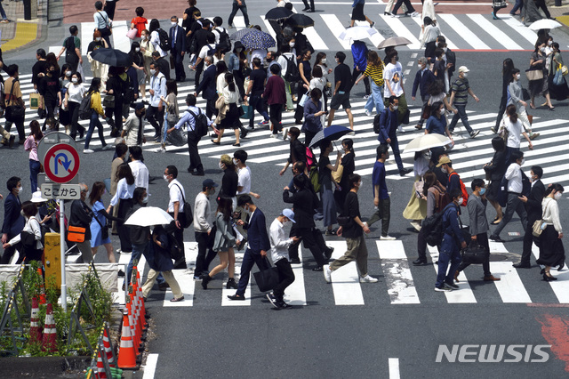 [도쿄=AP/뉴시스]14일 일본 도쿄에서 코로나19 확산을 막기 위해 마스크를 쓴 시민들이 건널목을 건너고 있다. 2021.05.14. 